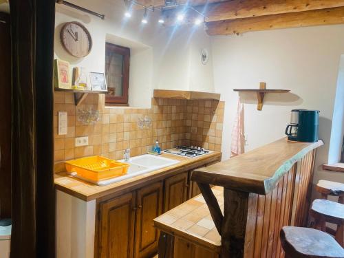 a kitchen with a sink and a clock on the wall at Chalet individuel à Ustou 09 in Ustou