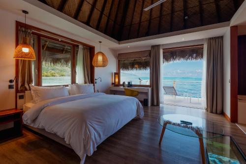 a bedroom with a bed and a view of the ocean at Tahiti Lagoon Resort in Punaauia