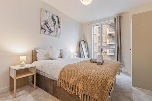 a bedroom with a large bed and a window at Luxury 2BR Apartment I Sleep 8 I Direct to Wembley & Euston in Hatch End