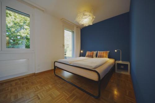 a bedroom with a bed with a blue wall at Traumhafte 2,5-Zi-Wohnung -B- mit Sicht auf See und Berge in Alpnach