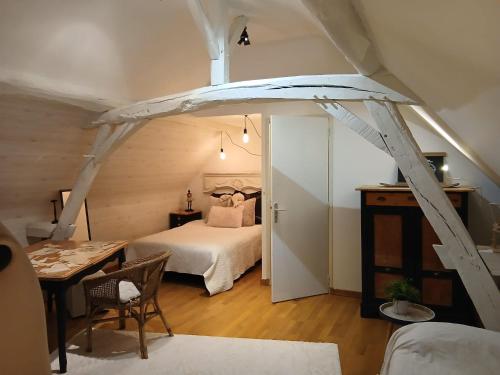 a bedroom with a bed and a table in a room at La parenthèse bucolique in Sepmes