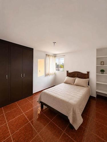 a bedroom with a large bed and a window at Casa ejecutiva para 10 personas in Gómez