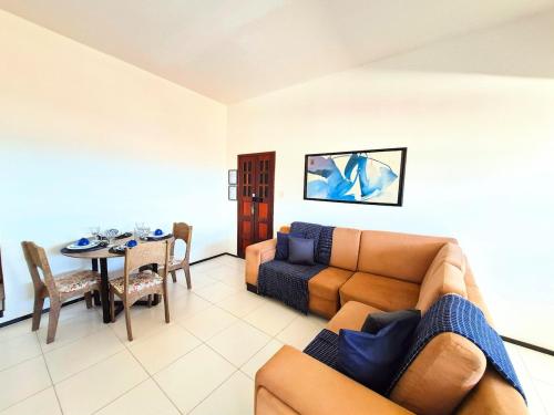 a living room with a couch and a table at Apartamento com varanda e VISTA para RUA, TV e 2 suítes in Teixeira de Freitas