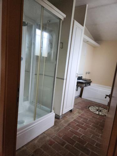 a glass shower in a bathroom with a tub at Il Pozzo dei desideri Shabby in Spilimbergo