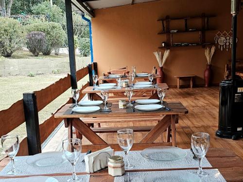 a wooden table with plates and glasses on it at Rio Cabañas in Huerta Grande