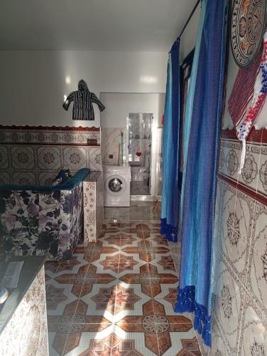 a bathroom with a tile floor and a washing machine at Dar Salima in Chefchaouen