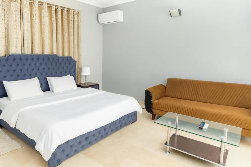 a bedroom with a bed and a couch at Divon B&B in Islamabad