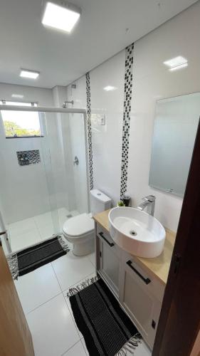 a white bathroom with a sink and a toilet at Villa Serena Garden - Quarto Cama Queen - Banheiro Compartilhado in Cascavel