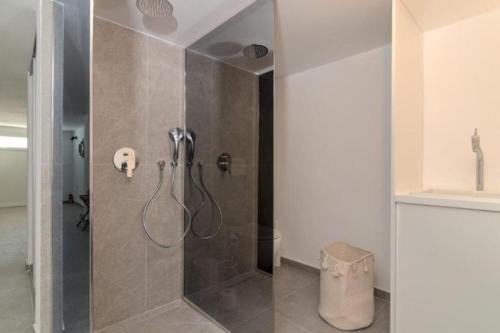 a bathroom with a shower with a glass door at House Nika in Punat