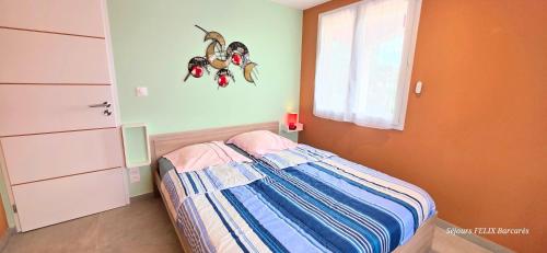 a small bedroom with a bed and a window at LE BARCARES Logement "Marenda" climatisé avec terrasse, plage à pied, place de parking - 4 personnes in Le Barcarès