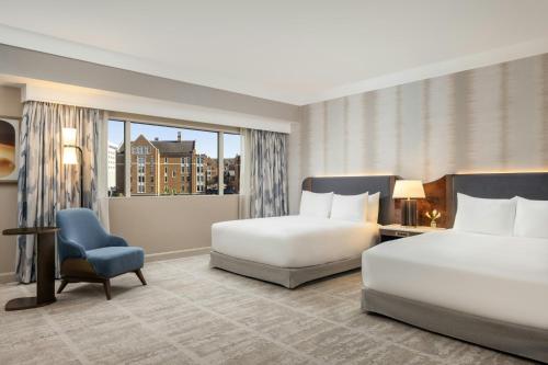 a hotel room with two beds and a chair at Loews Nashville Hotel at Vanderbilt Plaza in Nashville
