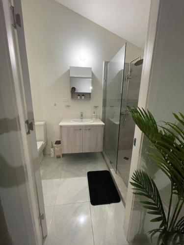a white bathroom with a sink and a shower at Discovery Bay Villa and Beach Club in Discovery Bay
