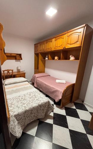 a bedroom with two beds and a checkered floor at Casa Paula Ardales caminito del Rey in Ardales