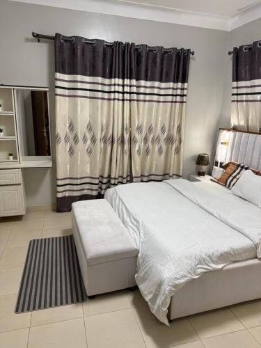 a bedroom with a bed and a window with curtains at Summer villas in Kampala