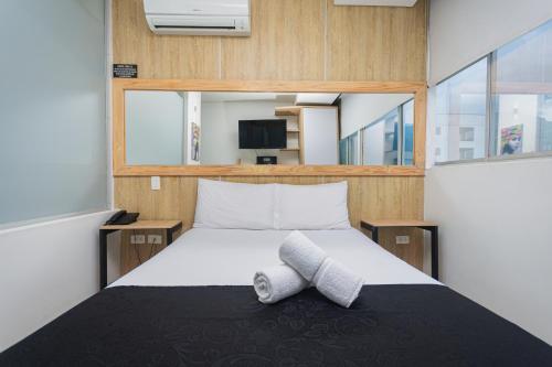 a bedroom with a bed with two towels on it at Hotel Piso 12 in Bello