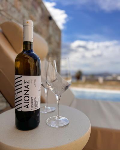a bottle of wine and a wine glass on a table at Thea Syros in Ermoupoli