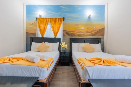 two beds in a room with a painting on the wall at "Hotel Relax" in Las Pozas