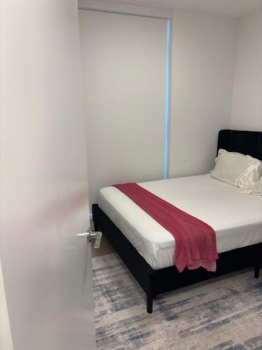 a bedroom with a bed with a red blanket on it at Executive 2 bed luxury Suit in Surrey