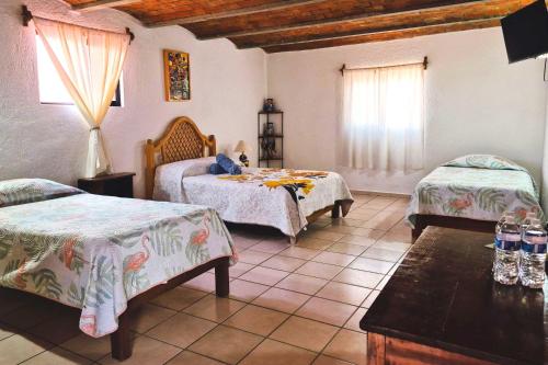a bedroom with two beds and a table and a window at Casa Manzanos in Guanajuato
