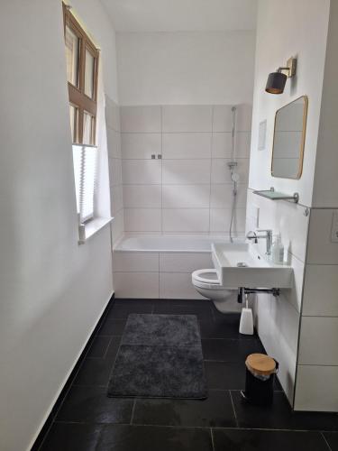 a bathroom with a sink and a tub and a toilet at Logierhaus Hoppegarten direkt an der Rennbahn mit perfekter S-Bahn Anbindung in Hoppegarten