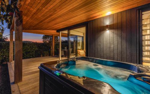a jacuzzi tub in the backyard of a house at Moa 30 Runga - Coast & Country in Oneroa