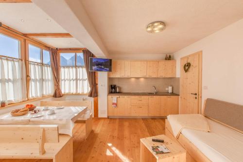 a kitchen and living room with a table and a couch at BIO Ranerhof in San Candido