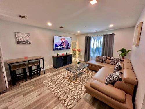 a living room with a couch and a tv at The Cozy Suite - 1BR with Free Parking in Paterson