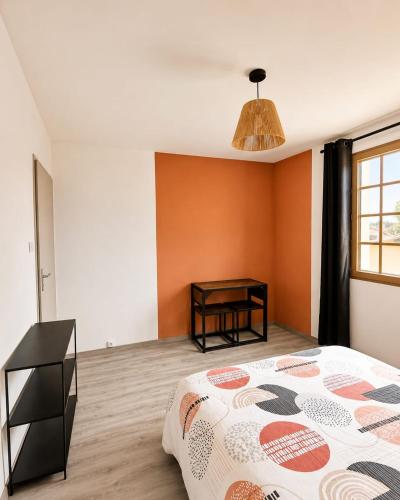 a bedroom with a bed and a table in it at Ambre in Bény