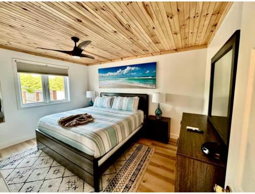 a bedroom with a large bed and a wooden ceiling at Beach Villa Blue Bahamas in Mayaguana Island