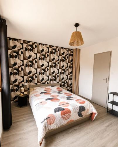 a bedroom with a bed with a patterned wall at Ambre in Bény