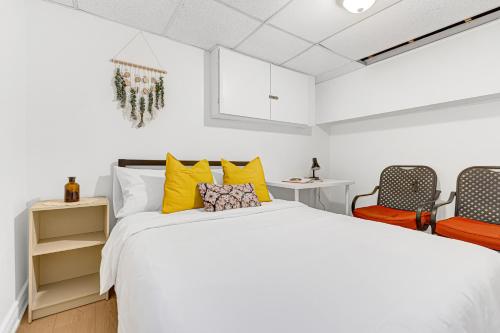 a bedroom with a large bed and two chairs at Bright 2BR Basement Apartment with Free Parking in Toronto