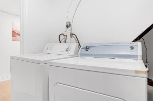 a white kitchen with a white dishwasher and a sink at Bright 2BR Basement Apartment with Free Parking in Toronto