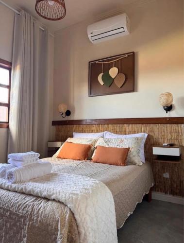 a bedroom with a large bed with orange pillows at Vila Maytrea Chalés in Alto Paraíso de Goiás