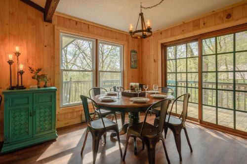 a dining room with a table and chairs and windows at Mountain Stay Chalet in Beech Mountain