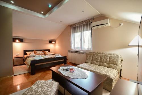 a small living room with a bed and a couch at D apartmani in Sremska Kamenica