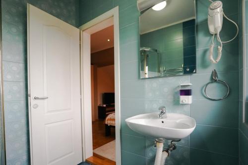 a bathroom with a sink and a mirror at D apartmani in Sremska Kamenica