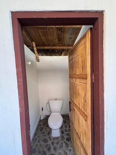 a bathroom with a toilet and a wooden door at Mar y Montana in Taganga
