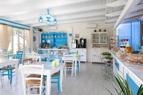 a dining room with white tables and blue cabinets at PALMASERA CHARMING - Rooms & Suites in Cala Gonone