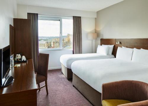 a hotel room with two beds and a window at Leonardo Hotel Derby in Derby
