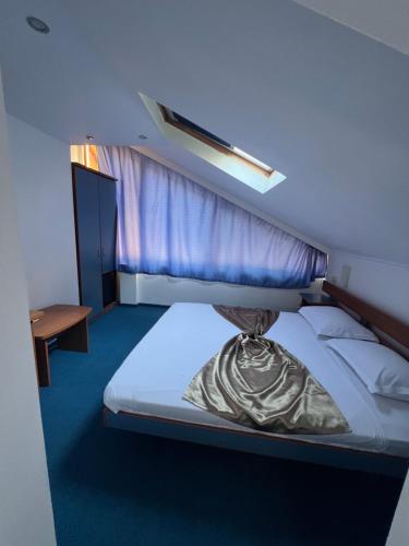a hotel room with a bed with a window at Vila Rosa Maria in Mangalia