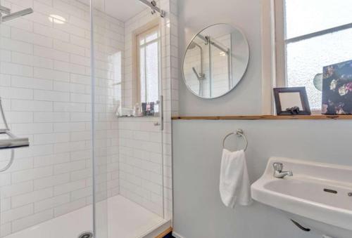 a bathroom with a shower and a sink and a mirror at Ruawai Post Office Accommodation in Ruawai