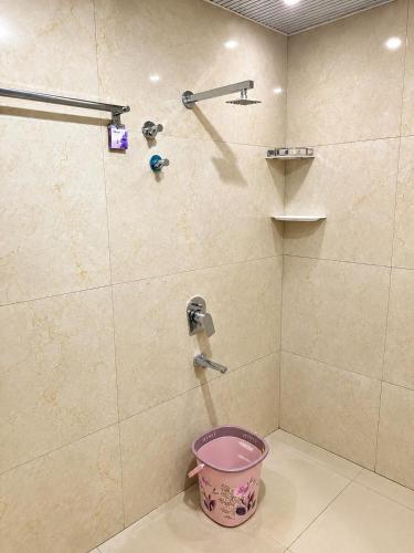 a shower with a pink bowl in a bathroom at JK Suites in Rāmachandrapuram