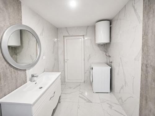 a white bathroom with a sink and a mirror at Bate Bole Mountain Villa in Elshani