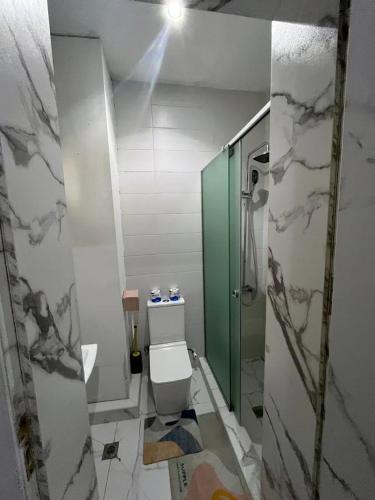 a bathroom with a toilet and a glass shower stall at Pcg Homes in Lagos