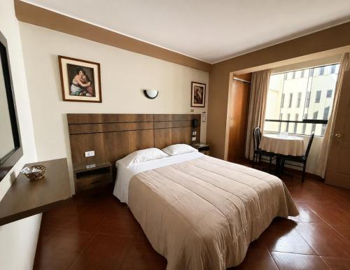 a hotel room with a bed and a table at Hotel Bohemia in Lima