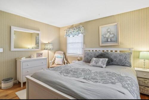 a bedroom with a bed and a dresser and a mirror at Perfect Cape Escape ! in Harwich