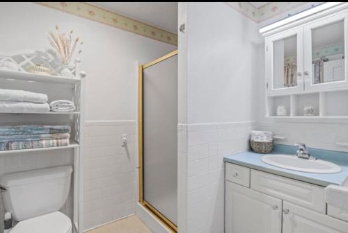 a white bathroom with a toilet and a sink at Perfect Cape Escape ! in Harwich