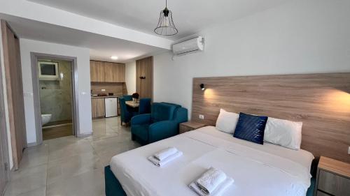 a bedroom with a large bed and a blue chair at OLIVE GARDEN APARTMENT in Bar