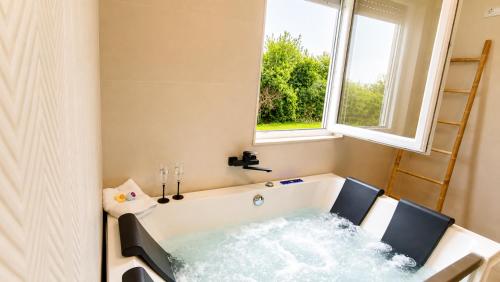 a bathtub with water in it in front of a window at O Retiro da Costa Galitrips in Muxia