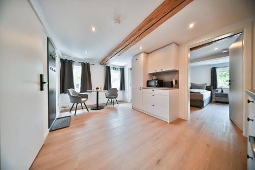 a living room with a bed and a dining room at Hotel M&H Apartments - Salzgitter in Salzgitter